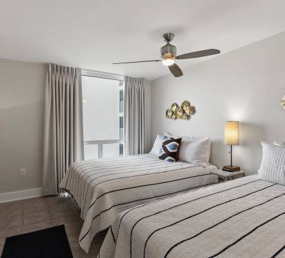 Drift off in your peaceful twin bedroom with city views, gentle ceiling fan breeze, and modern coastal touches.