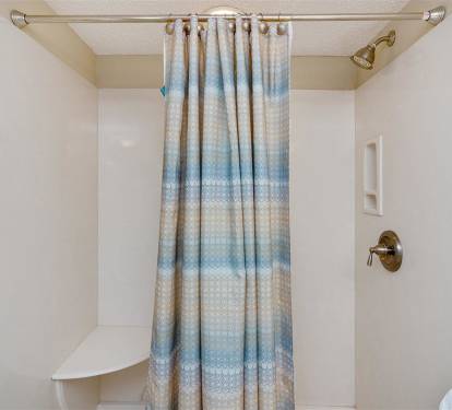 Step into your private sanctuary with a refreshing rainfall shower, soft coastal-inspired curtain, and plush towels waiting for you.