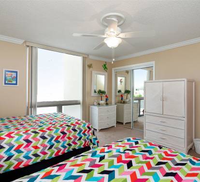 Drift off to sleep in this cheerful bedroom featuring vibrant geometric bedding and bright natural light streaming through your windows.