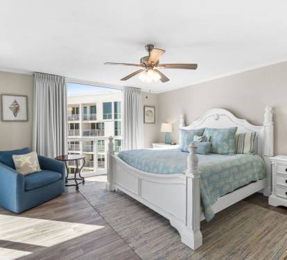 Your master bedroom retreat features elegant coastal decor, premium bedding, and balcony access with natural light streaming through.