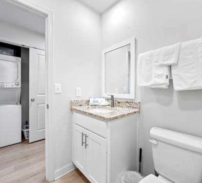 Fresh towels await in your pristine bathroom, complete with granite countertops and convenient laundry access.
