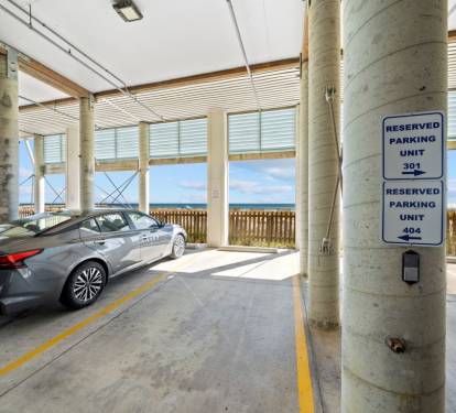 Your reserved parking spot ensures convenient access to your beachfront getaway, with the ocean just steps away from this covered garage.