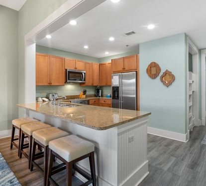 Your open-concept kitchen flows seamlessly into the living space, featuring granite countertops, stainless appliances, and a breakfast bar perfect for morning coffee.