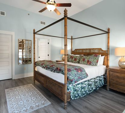 Unwind in your elegant four-poster bed surrounded by soothing coastal hues and tropical bedding that whispers of island dreams.