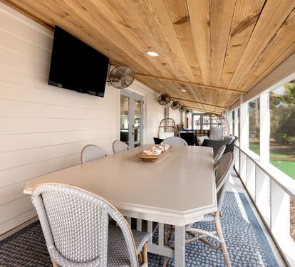 Gather around your private covered porch for meals under the warm wood ceiling, with garden views and entertainment ready for memorable moments.