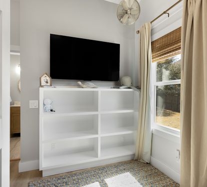 Unwind in your cozy bedroom with flat-screen TV and peaceful garden views through bamboo-shaded windows.