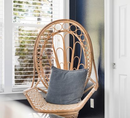 Sink into this cozy peacock chair, where natural light and soft cushions create your perfect reading nook.