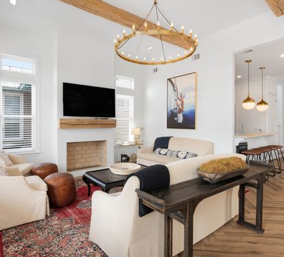 Unwind in your elegant living space with vaulted ceilings, rustic beams, and cozy fireplace creating the perfect atmosphere for relaxation.