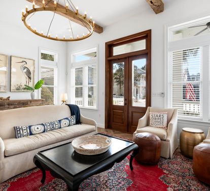 Unwind in your elegant living space with rustic beams, cozy seating, and charming coastal artwork creating the perfect retreat atmosphere.