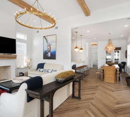 Unwind in this bright, open living space where coastal charm meets modern comfort with soaring ceilings and warm wood touches.