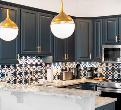 Your stylish kitchen features bold blue cabinetry, stunning patterned backsplash, and gleaming marble counters perfect for cooking memorable meals.