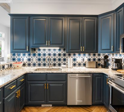 Cook your favorite meals in this stunning kitchen with bold navy cabinets, striking tile backsplash, and premium stainless appliances.