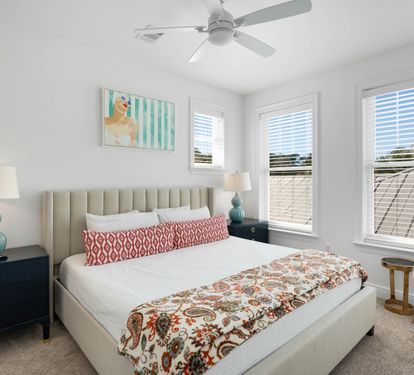Sink into your plush bed surrounded by cheerful artwork, turquoise accents, and refreshing ceiling fan breezes in this bright, stylish retreat.