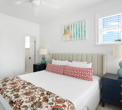Drift into peaceful sleep in your bright bedroom with plush bedding, stylish coastal decor, and cheerful natural light streaming in.