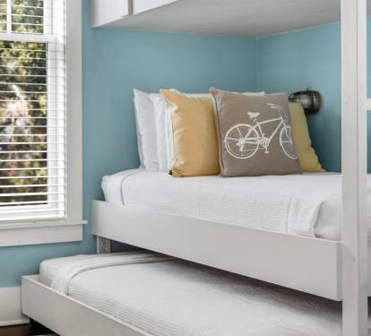 Relax in your serene space with cheerful accents and natural light filtering through stylish blinds.