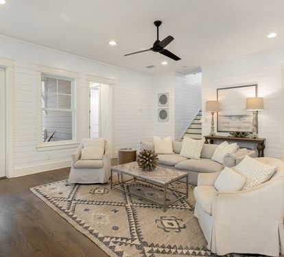 Relax in your spacious living room with plush sectional seating, stylish décor, and ceiling fan for perfect comfort.