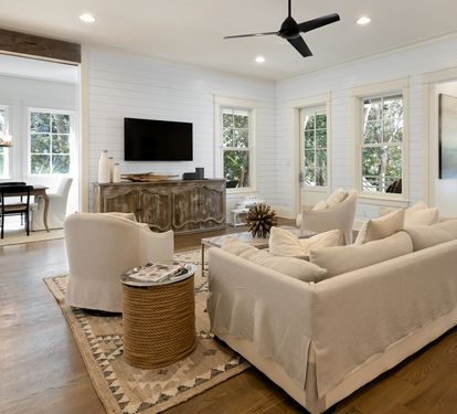 Relax in your elegant living space with shiplap walls, plush seating, and modern amenities for the perfect getaway.