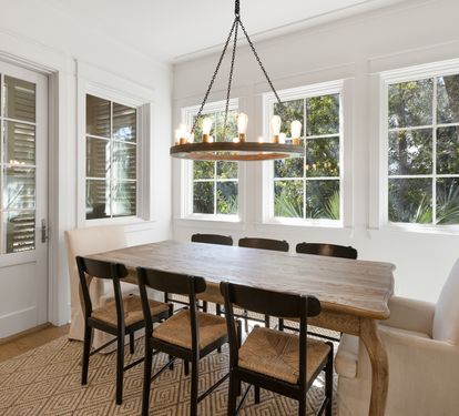 Gather around this beautiful dining table where natural light pours through large windows, creating the perfect ambiance for memorable meals together.