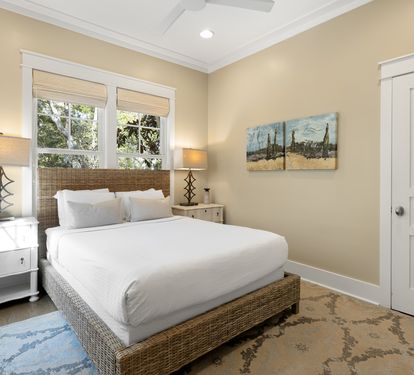 Slip into crisp white linens in your serene retreat, where warm natural light and coastal artwork create the perfect atmosphere for rest.