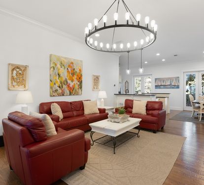 Relax in your spacious open-concept living area with rich leather seating and stunning chandelier, creating the perfect space for memorable gatherings.