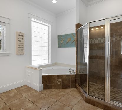 Unwind in your luxurious ensuite with a deep soaking tub and spacious walk-in shower featuring elegant tile work.