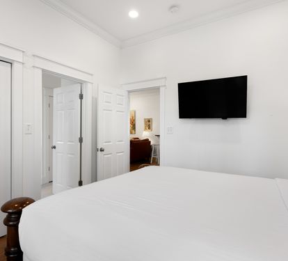 Unwind in your serene bedroom with crisp white linens, modern TV for entertainment, and abundant storage for all your belongings.
