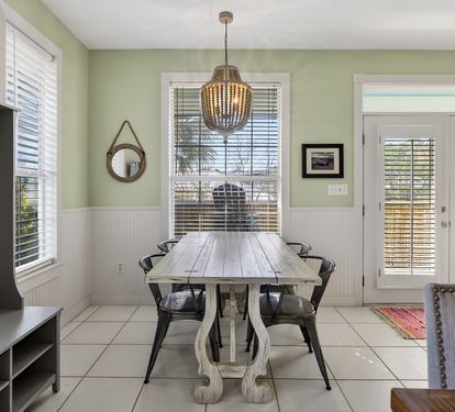 Gather around your elegant dining table under the warm chandelier glow, perfect for memorable meals and conversations.