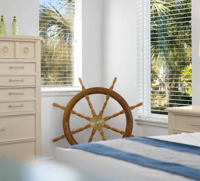 Your coastal bedroom features nautical charm with a ship's wheel centerpiece, tropical views, and soothing ocean-inspired decor.