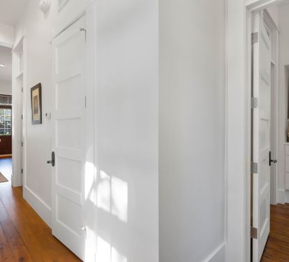 Step into this bright, welcoming hallway where rich hardwood floors guide you through your spacious home away from home.