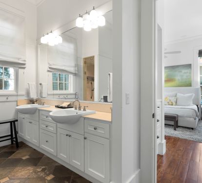 Pamper yourself in this elegantly appointed bathroom with dual vanities, modern lighting, and peaceful bedroom views.