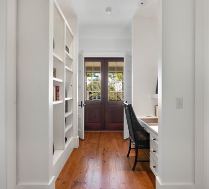 Your private study nook features built-in shelving, warm wood floors, and French doors opening to garden views—perfect for quiet work.