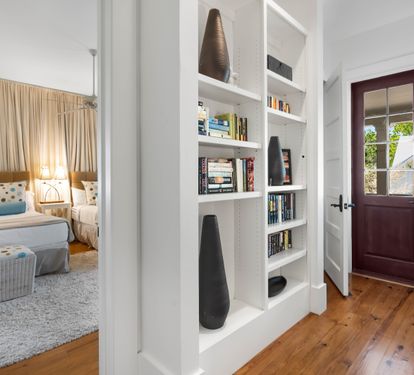 Step into your cozy bedroom featuring built-in bookshelves filled with reads for quiet evenings and warm hardwood floors throughout.