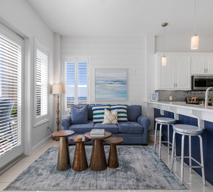 Your bright coastal retreat features an open-concept living space where blue accents meet crisp whites, creating the perfect backdrop for your beach getaway.