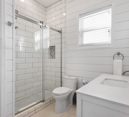 Unwind in your bright, modern bathroom featuring a spacious glass shower, crisp white subway tiles, and fresh towels waiting for you.