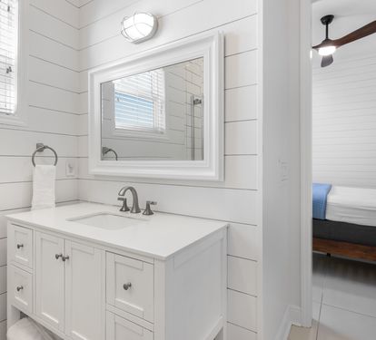 Step into your private retreat with spa-like style—crisp white shiplap walls, elegant vanity, and bright natural light create the perfect morning routine.