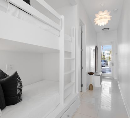 Drift off in this bright bedroom featuring custom bunk beds and stylish design touches that create a cozy retreat.