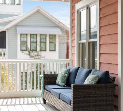 Step out onto your private balcony and sink into plush wicker seating with soft blue cushions and tropical-patterned pillows.
