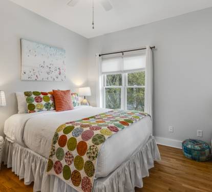 Unwind in your cheerful bedroom featuring colorful linens, natural light, and thoughtful touches that make every night's rest feel special.