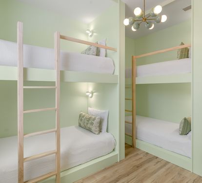 Rest easy in your stylish bunk bed sanctuary with soft green walls and modern lighting creating a peaceful retreat.