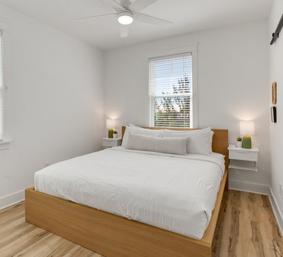 Drift off in your bright, airy bedroom with crisp linens and warm wood touches for the perfect night's rest.