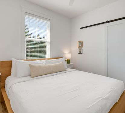 Wake up refreshed in your serene bedroom featuring crisp white linens and natural light streaming through your window.
