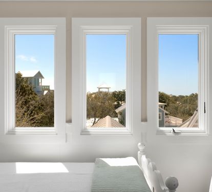 Wake up to peaceful mornings in your bright bedroom, where three picture windows frame leafy rooftops and blue skies.