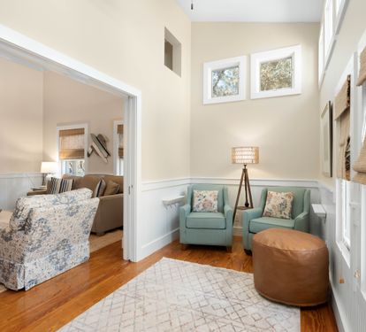 Settle into your cozy reading nook with twin aqua chairs and natural light streaming through windows.