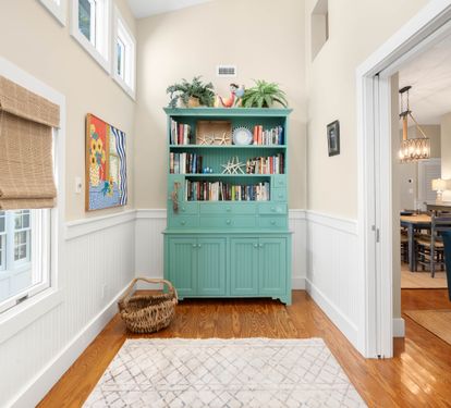 Your private reading nook awaits with turquoise built-ins, natural light, and cozy coastal charm perfect for morning coffee.