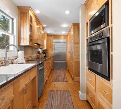 Your gourmet galley kitchen features warm wood cabinetry, granite counters, and premium appliances for memorable home-cooked meals.