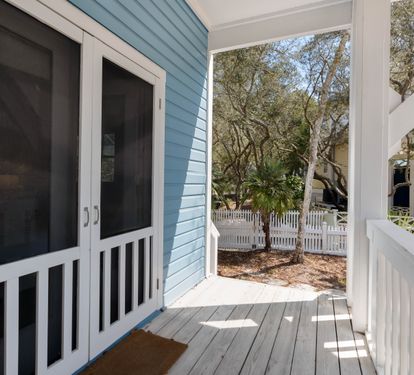 Your private entrance opens to a charming covered porch with peaceful garden views through mature trees.