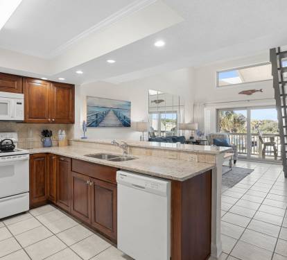 Your spacious kitchen boasts granite counters, rich wood cabinets, and modern appliances perfect for preparing coastal meals together.