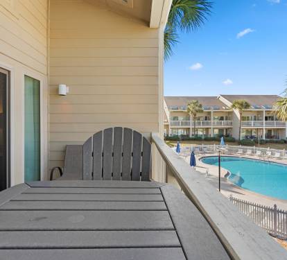 Relax on your private balcony with stunning pool views and tropical palms framing the perfect vacation backdrop.
