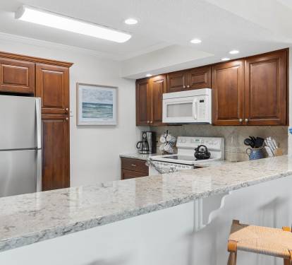 Your fully equipped kitchen features rich wood cabinets, granite counters, and stainless appliances—perfect for preparing meals during your stay.