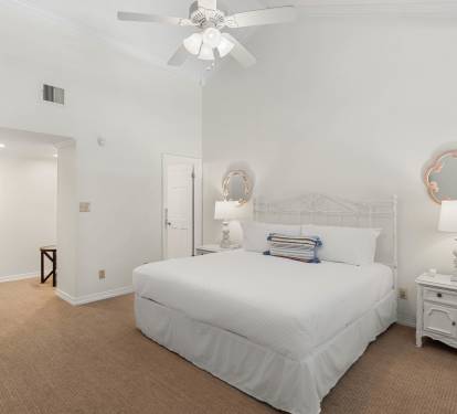 Rest peacefully in your bright bedroom featuring a plush queen bed, charming coastal decor, and convenient en-suite access.